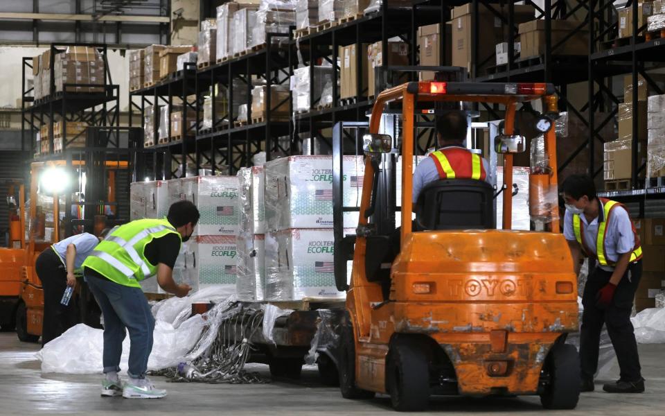 Workers transport Moderna vaccines shipped from the US to Taiwan Air Cargo Terminal in Taoyuan - Reuters