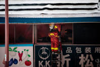 <p>A Japanese firefighter tries to extinguish a fire inside a shop at Tokyo’s Tsukiji fish market on August 3, 2017. (Photo: Behrouz Mehri/AFP/Getty Images) </p>