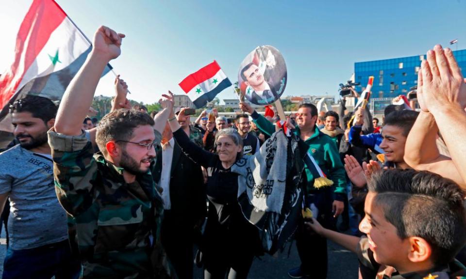 Syrians waving national flags and portraits of Bashar al-Assad at Umayyad Square.