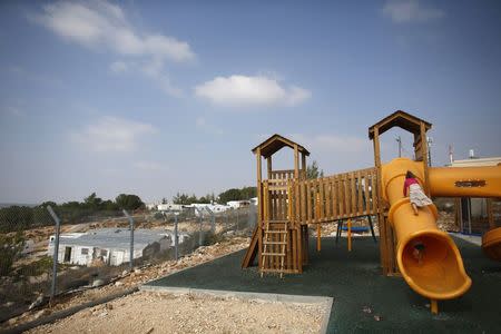 Children climb on a slide at a playground in a Jewish settlement in the Etzion settlement bloc, near Bethlehem August 31, 2014. REUTERS/Ronen Zvulun