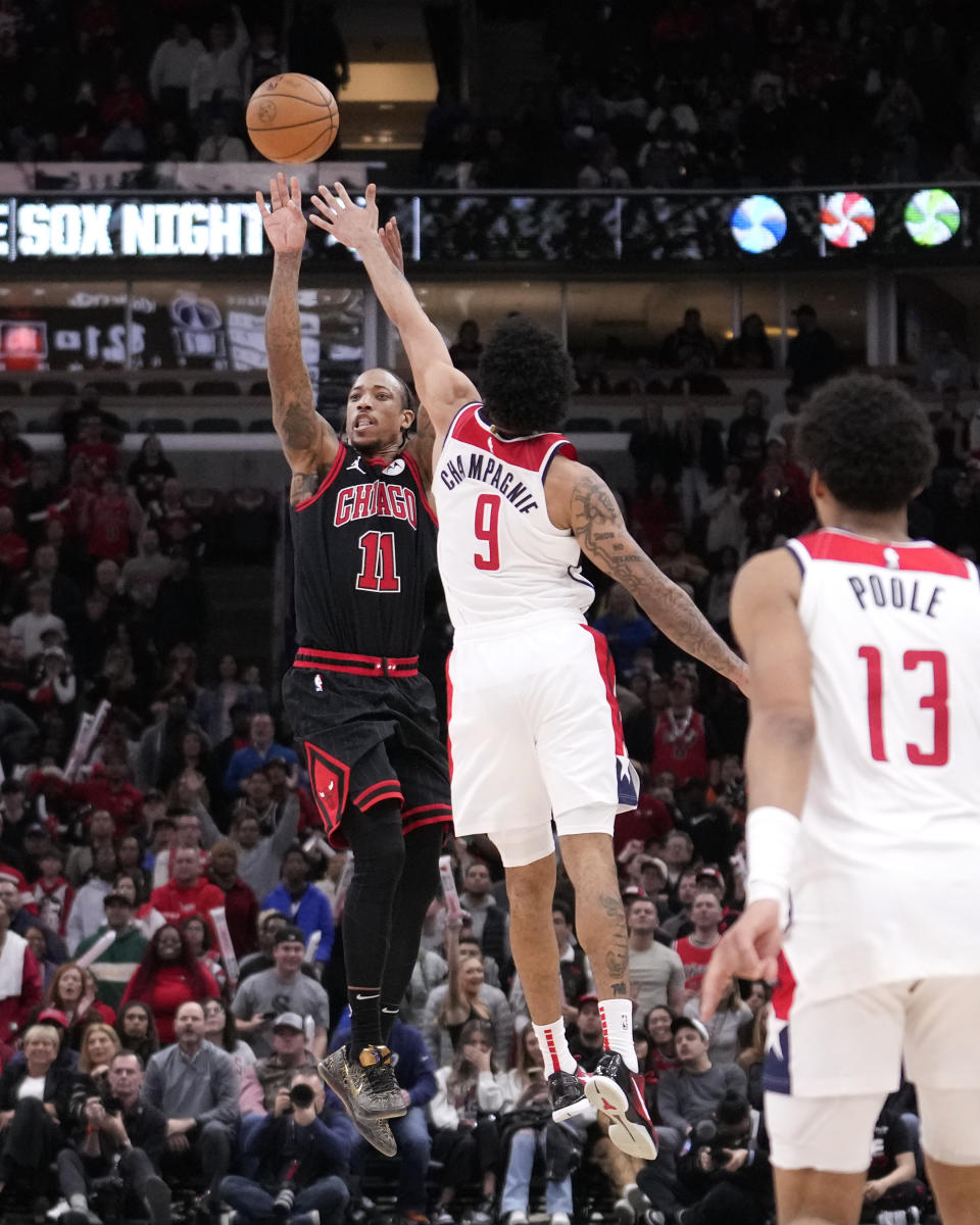 Chicago Bulls' DeMar DeRozan shoots a possible game winning 3-point basket, that fell short as Washington Wizards' Justin Champagnie defends at the end of an NBA basketball game Monday, March 25, 2024, in Chicago. The Wizards won 107-105. (AP Photo/Charles Rex Arbogast)