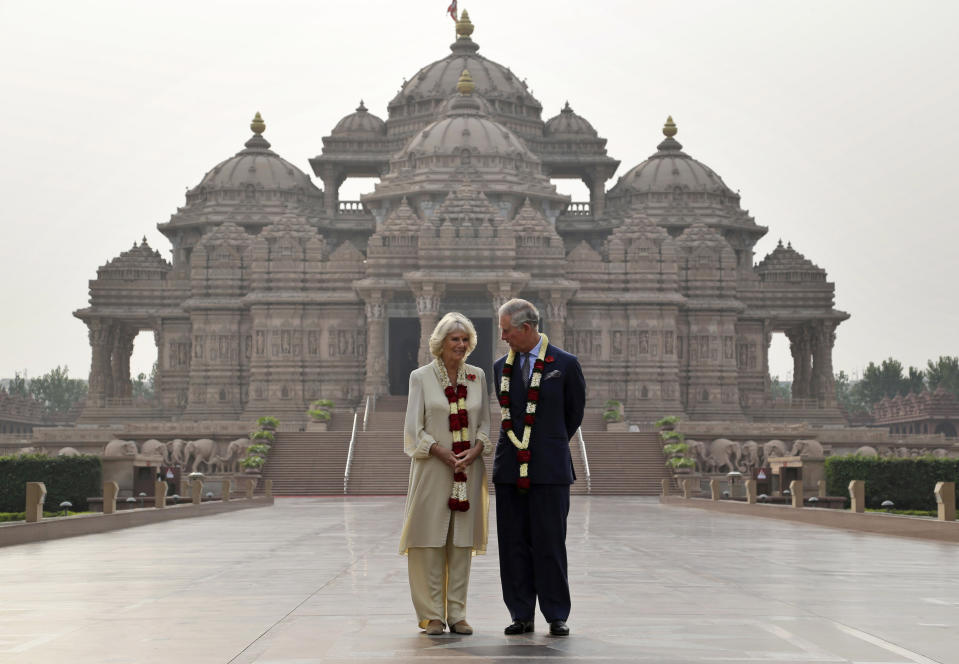 FILE - Britain's Prince Charles speaks with his wife Camilla, the Duchess of Cornwall, during their visit to Akshardham temple in New Delhi, India, Friday, Nov. 8, 2013. (AP Photo/Saurabh Das, File)