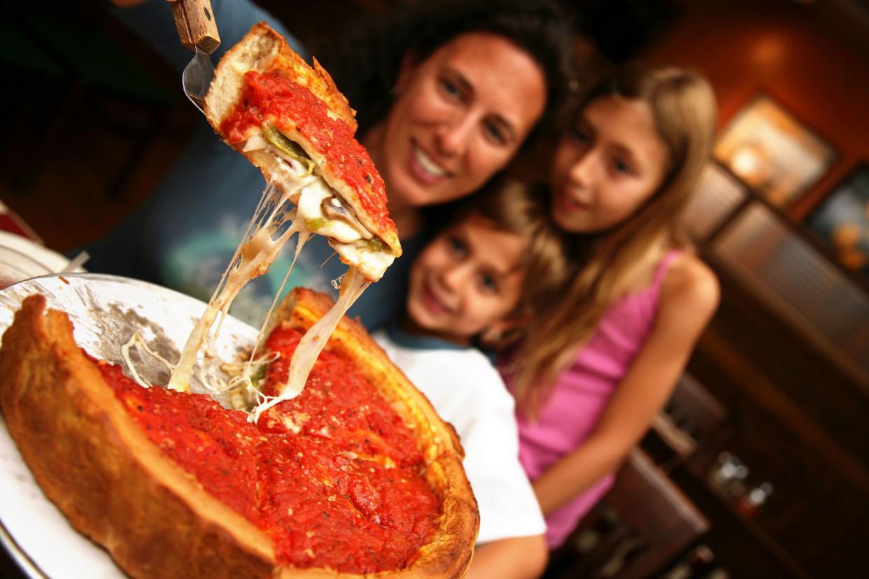 family enjoying deep dish pizza at restaurant