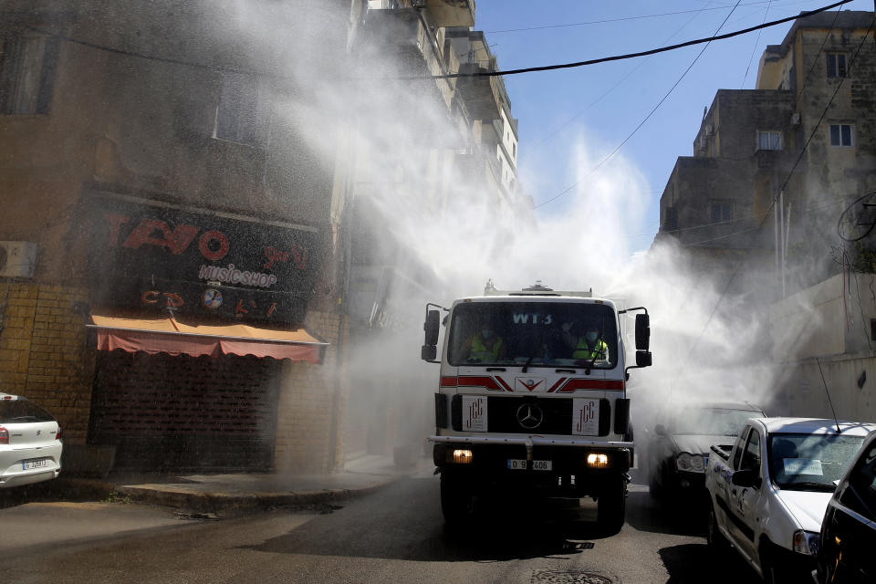 A municipal tanker sprays disinfectant as a precaution against the coronavirus outbreak in Beirut, Lebanon, Sunday, March 22, 2020. Lebanon has been taking strict measures to limit the spread of the coronavirus closing restaurants and nightclubs as well as schools and universities. For most people, the new coronavirus causes only mild or moderate symptoms. For some it can cause more severe illness. (AP Photo/Bilal Hussein)