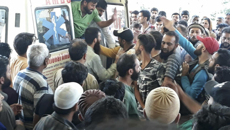 A crowd gathers around an ambulance carrying victims killed in a bus accident near Kishtwar, about 217 kilometers (135 miles) southeast of Srinagar, Indian-controlled portion of Kashmir, Friday, Sept. 14, 2018. The bus fell off a road into a deep gorge killing more than a dozen people. (AP Photo/Balbir Singh Jamwal)