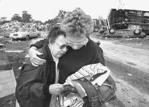 Josie Wolfe, left, is comforted by her neighbor Ann Legnard in front of Wolfe's destroyed home at the Ponderosa Campgrounds in Kissimmee, Florida, where a tornado hit on Feb. 22, 1998. The 73-year-old Wolfe said she had lost everything in the storm.