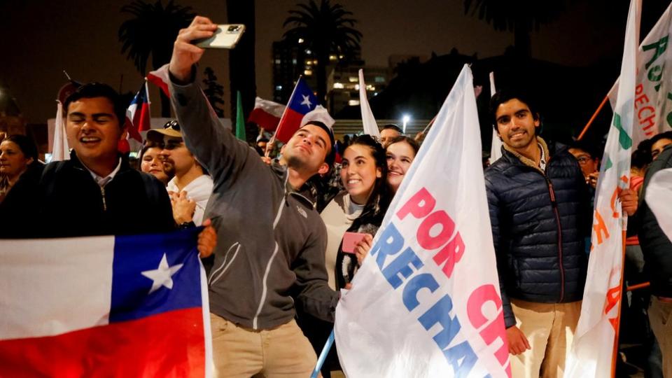 Manifestantes en las calles de Santiago de Chile con una bandera de rechazo.