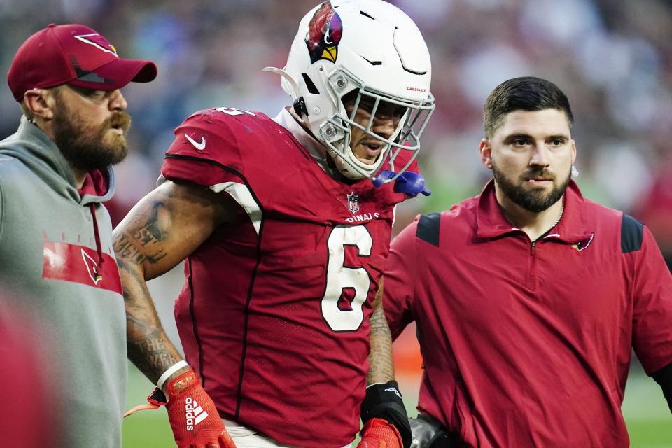 An injured Arizona Cardinals running back James Conner is helped off the field during the second half of an NFL football game against the Seattle Seahawks Sunday, Jan. 9, 2022, in Glendale, Ariz. The Seahawks won 38-30. (AP Photo/Darryl Webb)