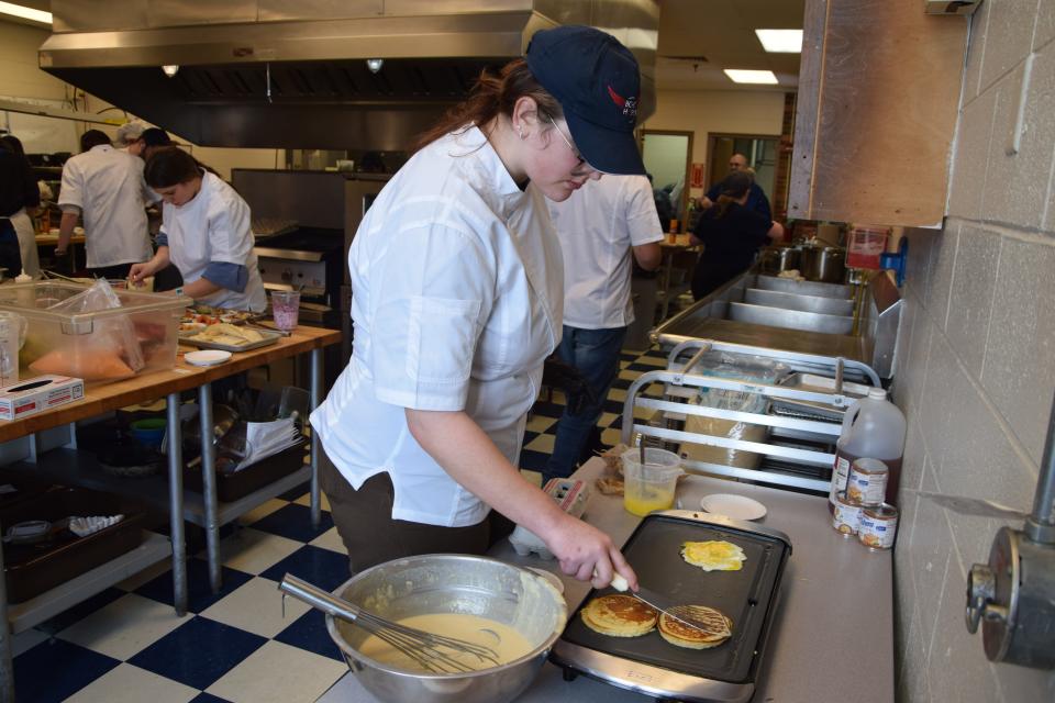 Boyne City High School student Eva Sommerfeldt manned the griddle, helping make breakfast sandwiches for her Food Truck Wars team on March 20, 2024.