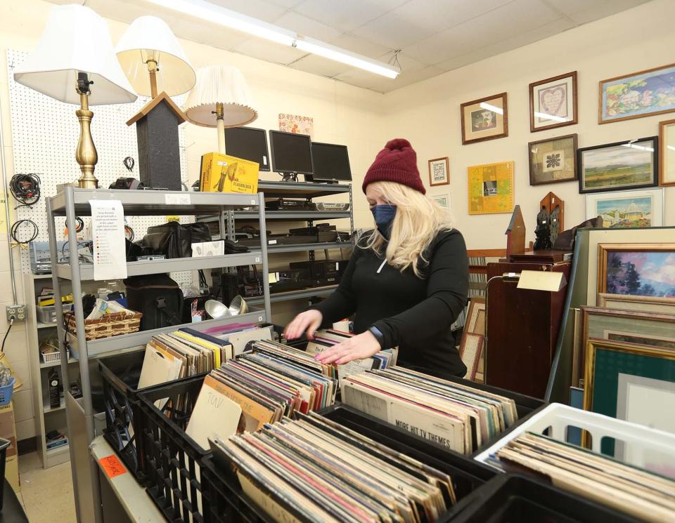 Catherine Altizer, manager at the Happy Tails Thrift Shop, looks through record albums at the Akron store.