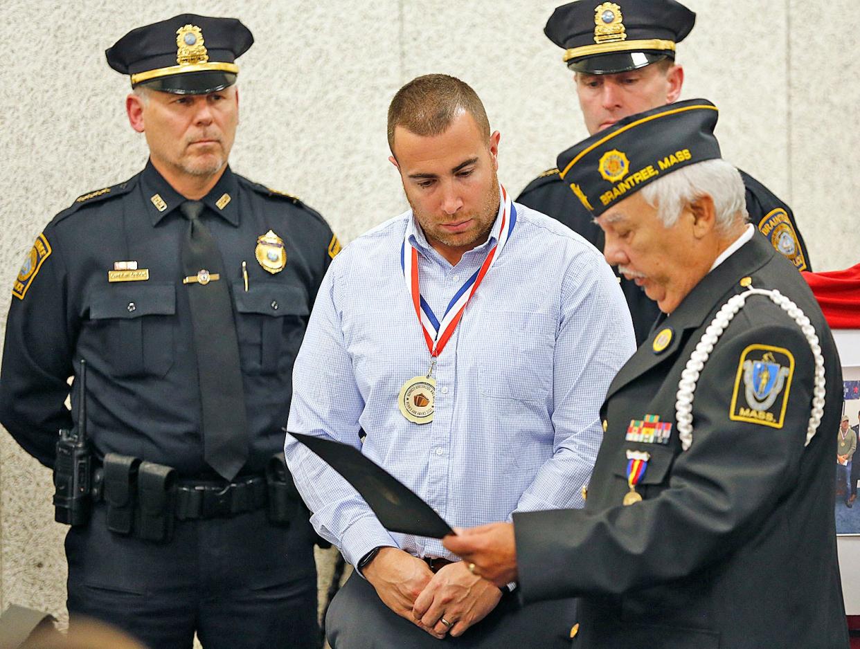 Braintree police officer Matthew Donoghue receives a World War II Peace Medal at the Braintree police station Thursday, Nov.11, 2021.