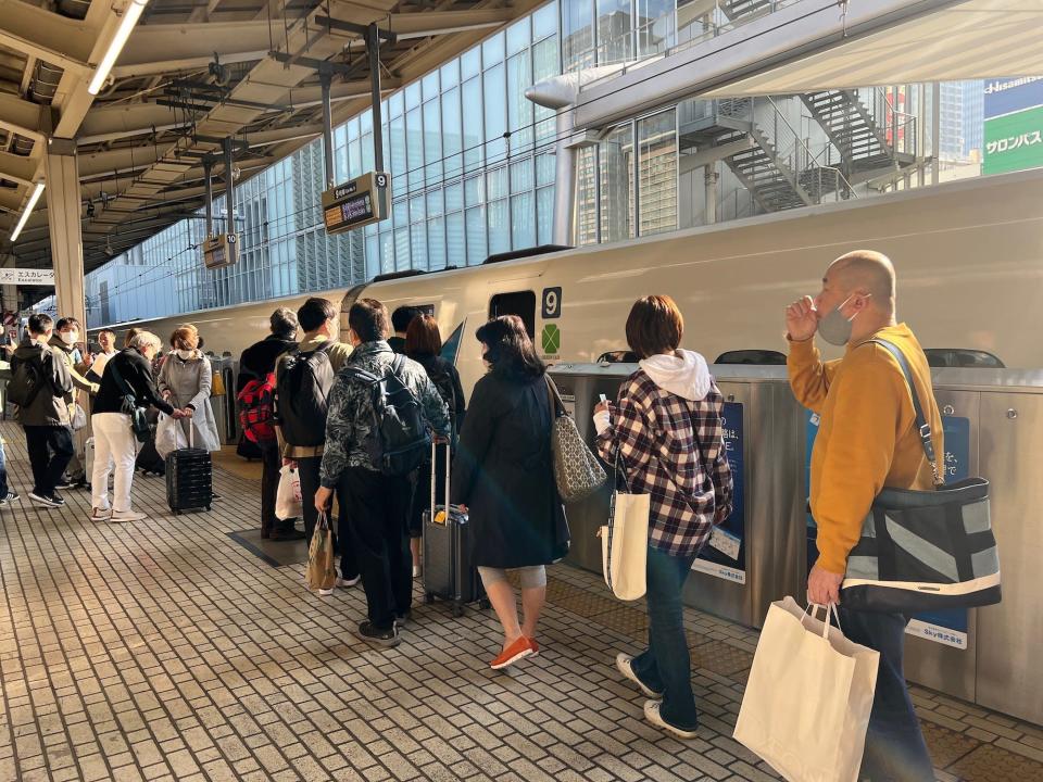 People waiting to board the Shinkansen train in Tokyo.