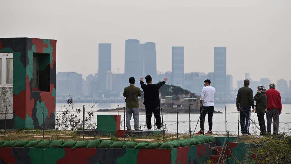 Tourists in Kinmen gaze at the skyline of Xiamen on December 5, 2023. - Sam Yeh/AFP/Getty Images