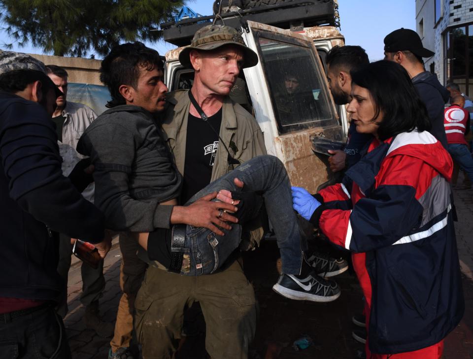 Dave Eubank of the humanitarian group Free Burma Rangers carries an injured Kurdish YPG soldier to a hospital in Tel Tamir, Syria in November 2019.  Photographer Carol Guzy recently spent a month  documenting the work of the Free Burma Rangers and the Turkish incursion into northern Syria.
