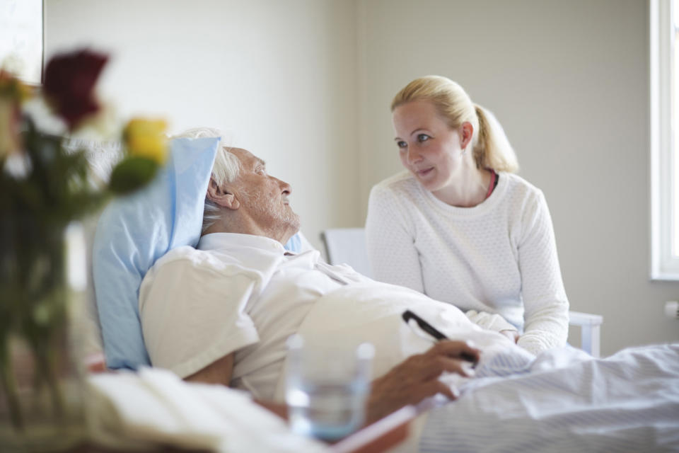 A woman talking to a patient in a hospital