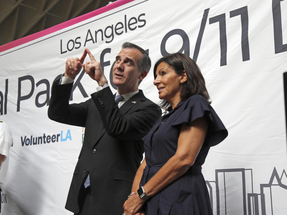 Los Angeles Mayor Eric Garcetti and Paris Mayor Anne Hidalgo share a moment following a ceremony marking the 17th anniversary of the Sept. 11, 2001 terrorist attacks on America, at the Los Angeles Fire Department's training center Tuesday, Sept. 11, 2018. Americans looked back on 9/11 Tuesday with tears and somber tributes. Victims' relatives said prayers for their country, pleaded for national unity and pressed officials not to use the 2001 terror attacks as a political tool in a polarized nation. (AP Photo/Reed Saxon)