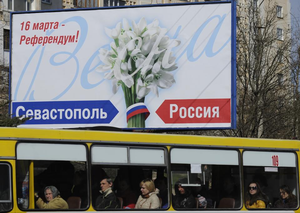 People ride in a bus by a poster reading "March 16 - Referendum! Sevastopol. Russia" in Sevastopol, Thursday, March 13, 2014. Crimea plans to hold a referendum on Sunday that will ask residents if they want the territory to become part of Russia. Ukraine's government and Western nations have denounced the referendum as illegitimate and warned Russia against trying to annex Crimea. (AP Photo/Andrew Lubimov)