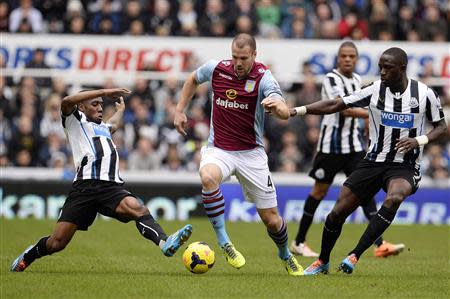 Newcastle United's Vurnon Anita (L) and Moussa Sissoko (R) challenge Aston Villa's Ron Vlaar during their English Premier League soccer match at St James' Park in Newcastle, northern England February 23, 2014. REUTERS/Nigel Roddis