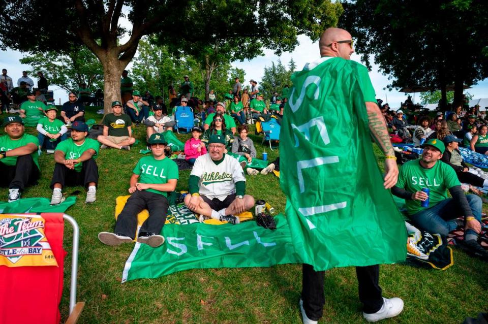 Last Dive Bar co-founder Bryan Johansen, right, wears a “SELL” flag like a cape during a protest Saturday at the River Cats game against the Las Vegas Aviators at Sutter Health Park. Johansen hopes Saturday’s protest will continue the movement that eventually pushes Fisher to sell the team.