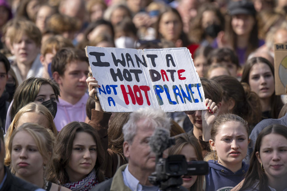 A sign reading "I want a hot date, not a hot planet" is held up in the crowd during a demonstration by climate activists in Berlin, Friday, Sept. 23, 2022. Youth activists staged a coordinated “global climate strike” on Friday to highlight their fears about the effects of global warming and demand more aid for poor countries hit by wild weather. (Monika Skolimowska/dpa via AP)