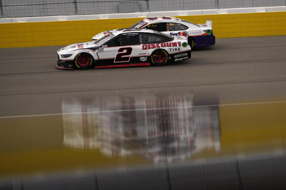 Brad Keselowski (2) and Denny Hamlin drive during a NASCAR Cup Series auto race Sunday, March 7, 2021, in Las Vegas. (AP Photo/John Locher)