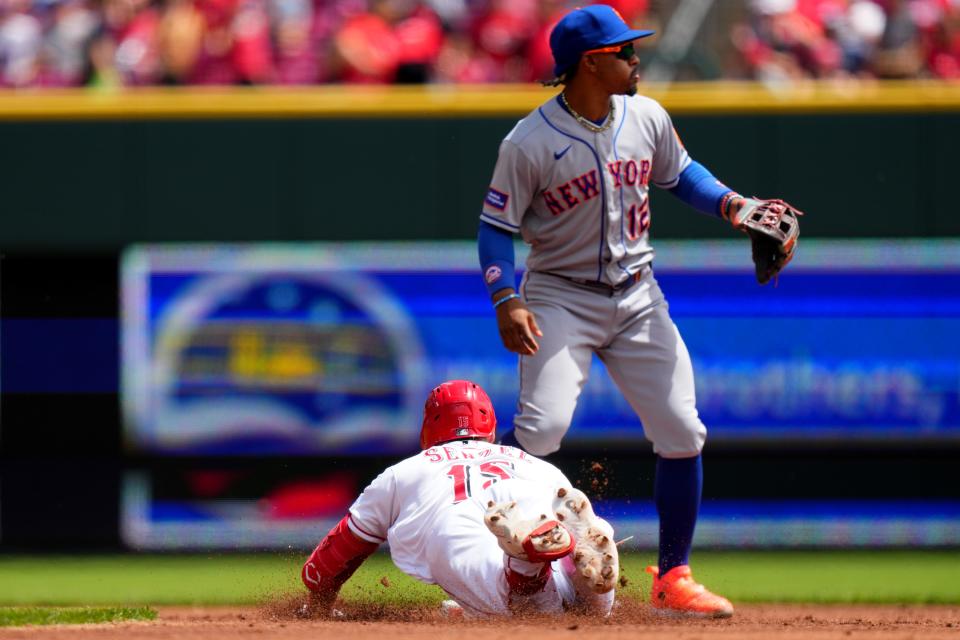 Cincinnati Reds center fielder Nick Senzel (15) slides in safely at second base after hitting a double in the first inning of a baseball game between the New York Mets and the Cincinnati Reds, Thursday, May 11, 2023, in Cincinnati.