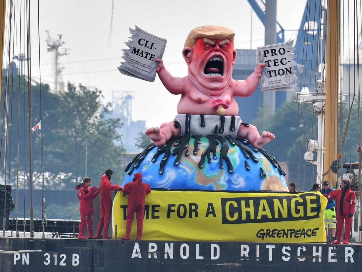 Greenpeace activists depicted the US president in Germany in 2017 tearing up a climate-protection agreement: Getty