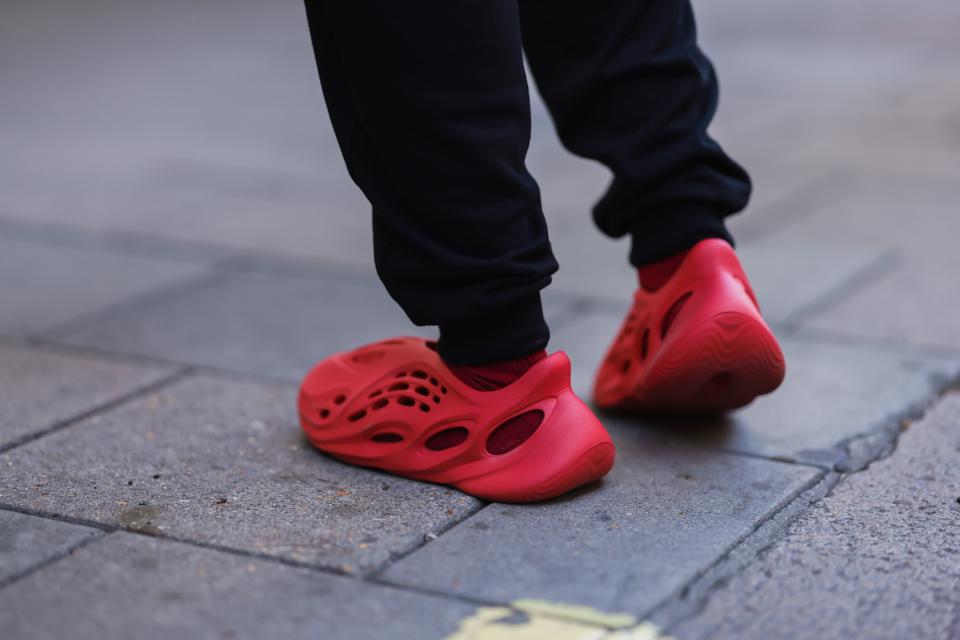 Feet wearing red Yeezy Adidas foam runner shoes