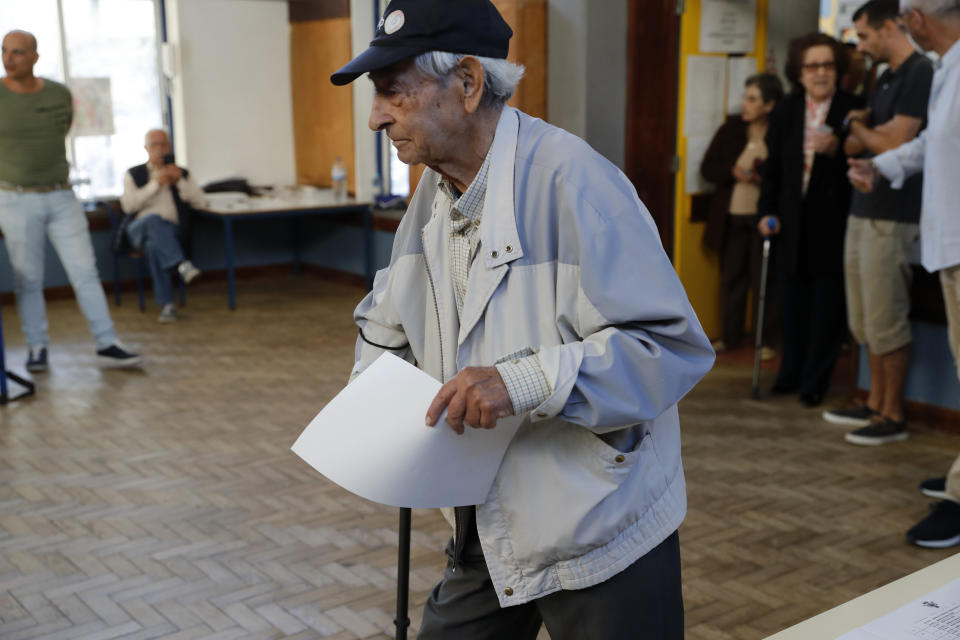 An elderly man walks to a voting booth to fill his ballot paper at a polling station in Lisbon Sunday, Oct. 6, 2019. Portugal is holding a general election Sunday in which voters will choose members of the next Portuguese parliament. (AP Photo/Armando Franca)
