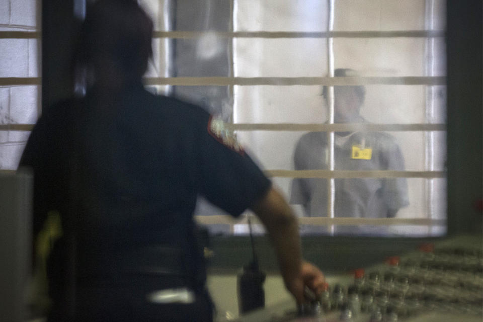 A prisoner looks at a corrections officer from behind several layers of glass and bars in the enhanced supervision housing unit at Rikers Island in New York on March 12, 2015. (Photo: Brendan McDermid/Reuters)