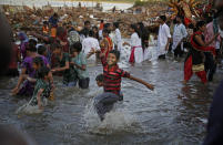 <p>An Indian Hindu boy dances in the River Yamuna during immersion of idols of goddess Durga on the final day of Durga Puja festival in New Delhi, India, Saturday, Sept. 30, 2017. The immersion of idols marks the end of the festival that commemorates the slaying of a demon king by lion-riding, 10-armed goddess Durga, marking the triumph of good over evil. (Photo: Altaf Qadri/AP) </p>