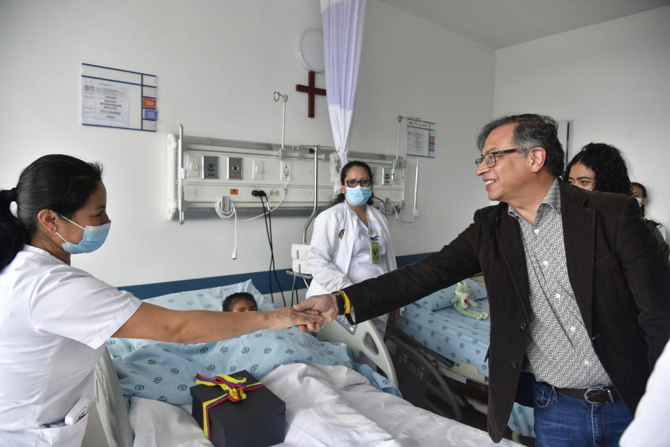 In this handout photo released by the Colombian Presidential Press Office, Colombia's President Gustavo Petro greets a nurse tending to one of the four Indigenous children who survived an Amazon plane crash that killed three adults and then braved the jungle for 40 days before being found alive, at a military hospital in Bogota, Colombia, Saturday, June 10, 2023. (Colombia's Press Office via AP)