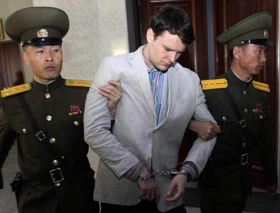 American student Otto Warmbier (centre) escorted at the Supreme Court in Pyongyang, North Korea on 16 March 2016 (AP)