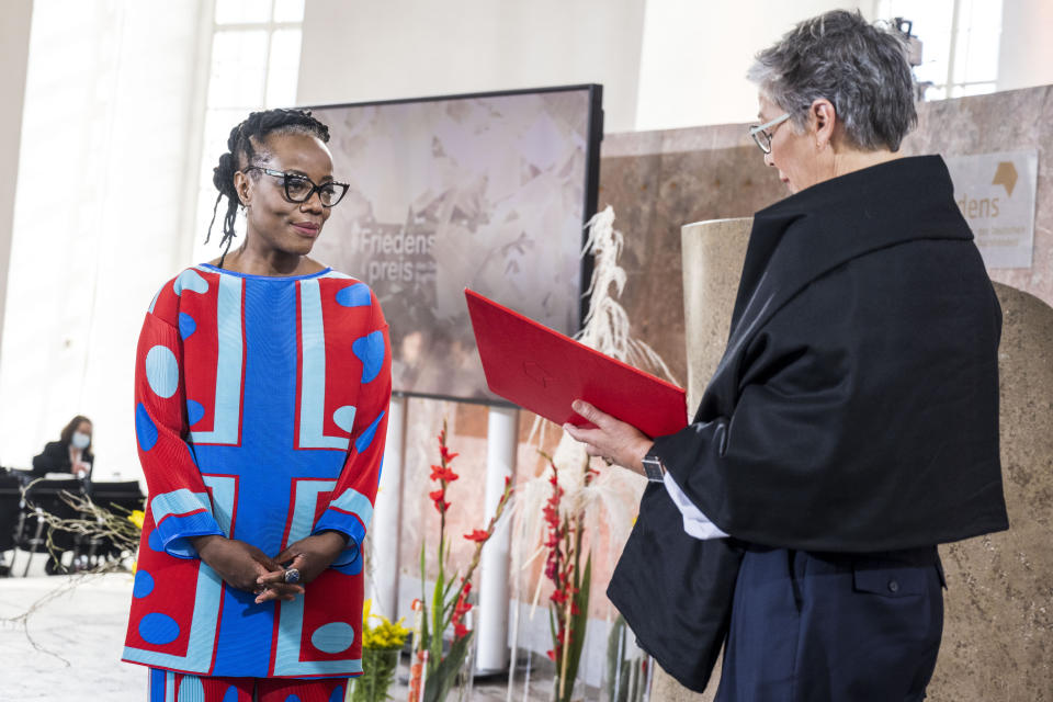 Author Tsitsi Dangarembga, from Zimbabwe, receives the Peace Prize of the German Book Trade from Karin Schmidt-Friderichs, president of the Börsenverein des Deutschen Buchhandels, in Frankfurt, Germany, Sunday, Oct. 24, 2021 (Thomas Lohnes/epd-Pool/dpa via AP)