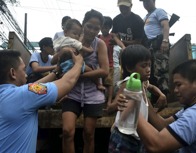 In this Thursday, Nov. 7, 2013 photo, residents living near the slopes of Mayon volcano are evacuated to public schools by police in anticipation of the powerful typhoon Haiyan that threatened Albay province and several provinces in central Philippines. The typhoon, one of the most powerful typhoons ever recorded, slammed into the Philippines early Friday, with one weather expert warning of catastrophic damage. (AP Photo/Nelson Salting)