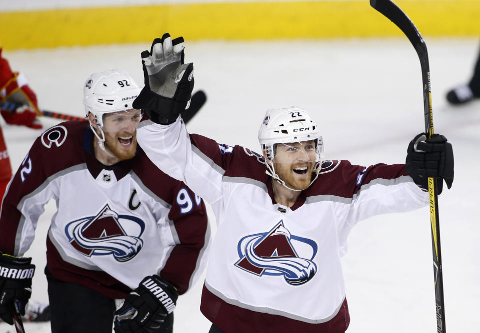 Colorado Avalanche center Colin Wilson (22) celebrates his goal against the Calgary Flames with teammate Gabriel Landeskog (92) during the second period of Game 5 of an NHL hockey first-round playoff series Friday, April 19, 2019, in Calgary, Alberta. (Larry MacDougal/The Canadian Press via AP)