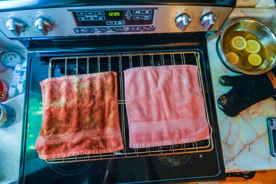 Two hand rags on a stove top, the one on the left is dirty from the oven and the one on the right is clean