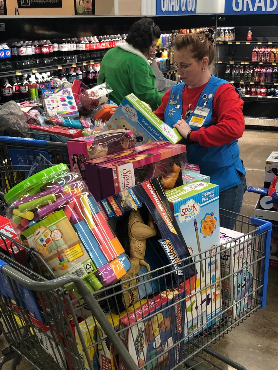 Jo Zurbrugg, a worker at the Alliance Walmart, and store manager Sarah McDonald pack shopping carts with toys bought by store employees and donated to the Salvation Army.