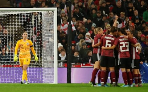 England's Mary Earps looks dejected as Germany's Alexandra Popp celebrates scoring their first goal with teammates - Credit: ACTION IMAGES