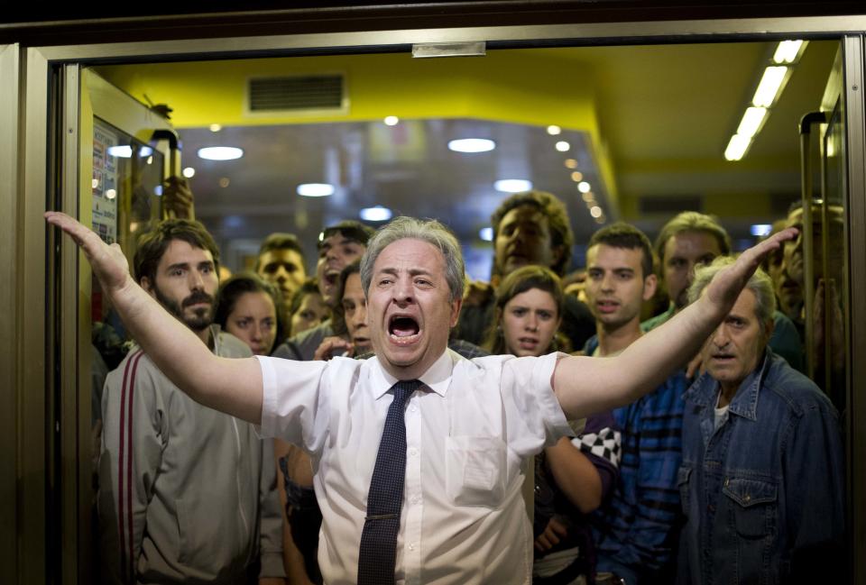 El dueño de un restaurante pide a los manifestantes que dejen de lanzar piedras a su establecimiento. Las protestas callejeras en las calles de Madrid fueron una constante durante el año, consecuencia de la grave crisis económica que afecta al país. (Photo by Jasper Juinen/Getty Images)