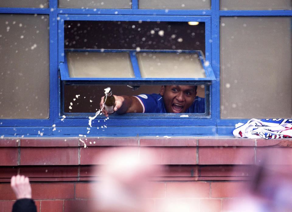 Rangers' Alfredo Morelos looks from a window as he celebrates with fans outside the ground after winning in the Scottish Premiership match against St Mirren, at Ibrox Stadium in Glasgow, Scotland, Saturday March 6, 2021. Some thousands of fans gathered outside the stadium celebrating the win against St. Mirren, putting them on the brink of securing the Scottish Premiership title. (Robert Perry/PA via AP)