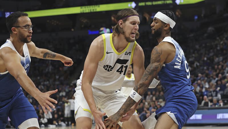 Utah Jazz forward Kelly Olynyk (41) handles the ball against Minnesota Timberwolves guard Nickeil Alexander-Walker (9) during the first half of an NBA basketball game Saturday, Nov. 4, 2023, in Minneapolis. (AP Photo/Stacy Bengs)