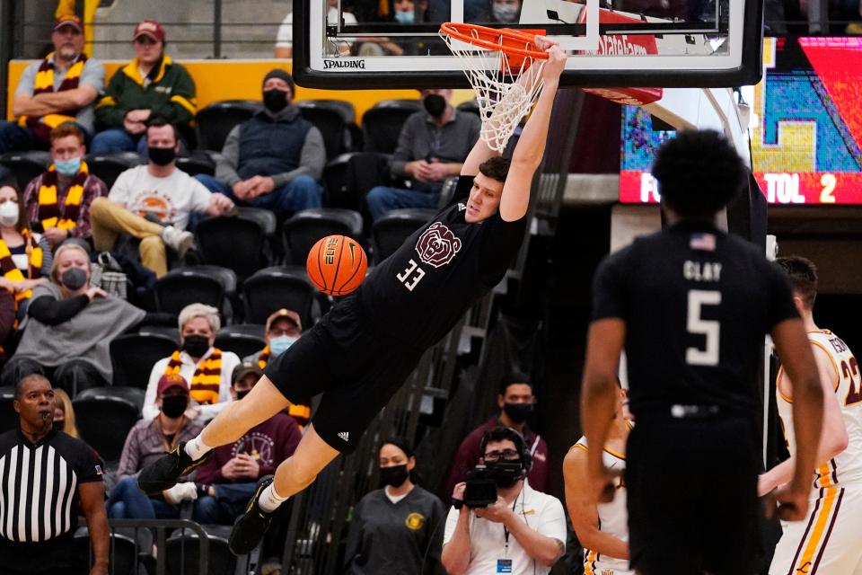 Missouri State center Dawson Carper (33) hangs from the rim after dunking against Loyola Chicago during the second half of an NCAA college basketball game in Chicago, Saturday, Jan. 22, 2022. (AP Photo/Nam Y. Huh)