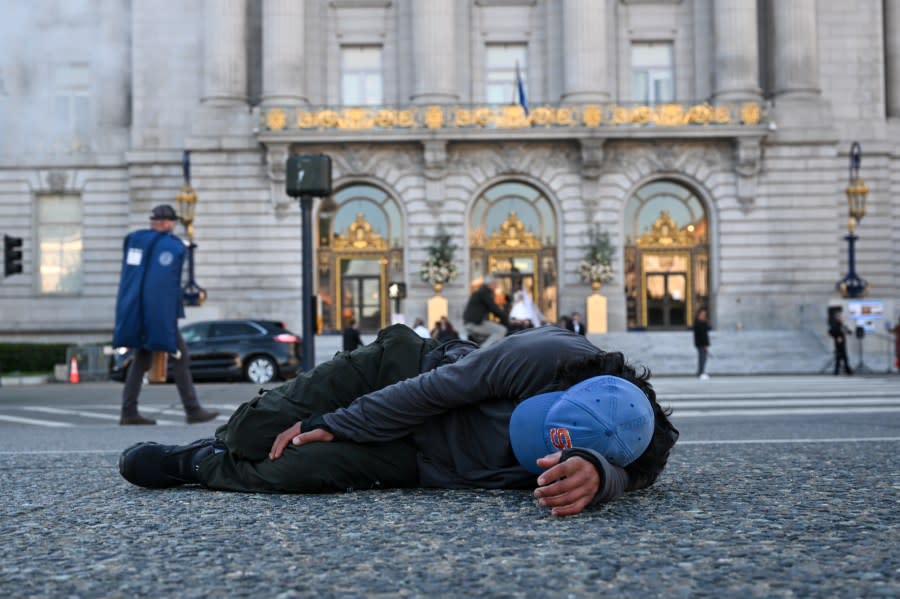 A homeless man sleeps on the sidewalk outside the City Hall while the APEC Economic Leaders’ Week was underway on Nov. 11, 2023 in San Francisco. (Photo by Tayfun Coskun /Anadolu via Getty Images)