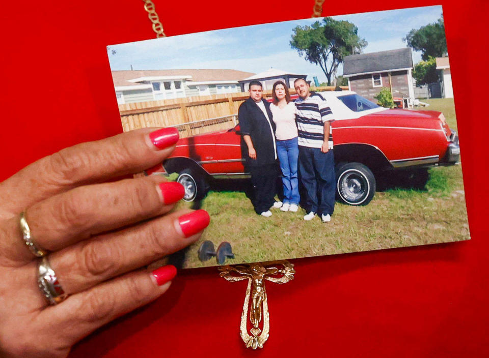 Paz Quezada holds a photo of her with her sons, Juan and Sergio Guitron. (Ivy Ceballo / Tampa Bay Times via ZUMA / Alamy)