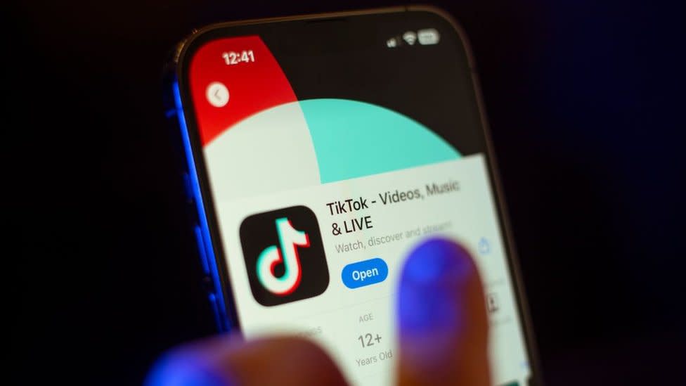 A mobile phone user clicks to download the TikTok app