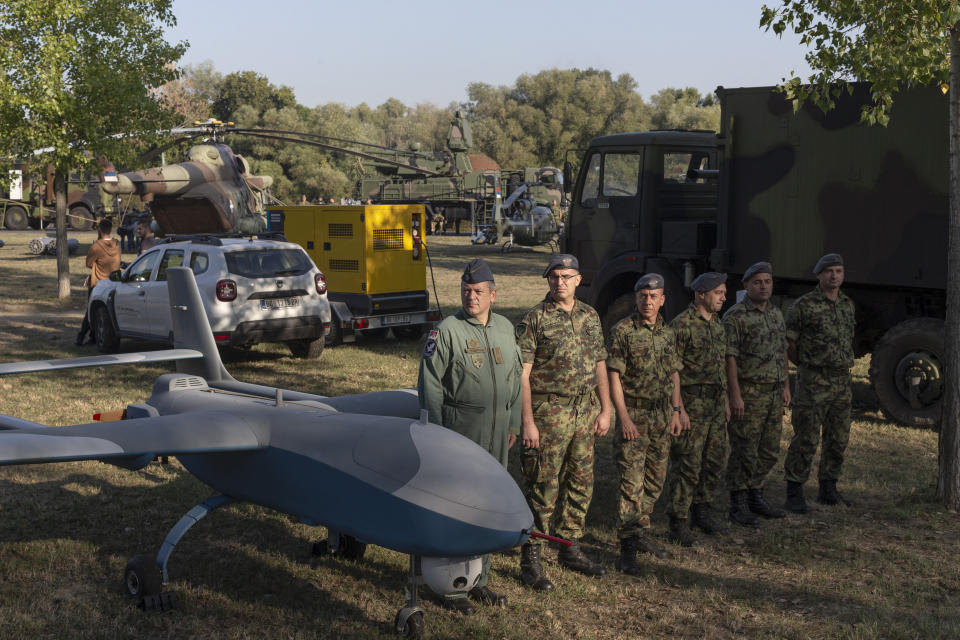 Serbian army soldiers stand to attention next to a military drone during an arms display as part of a newly established "Serbian Unity Day" holiday in Belgrade, Serbia, Wednesday, Sept. 15, 2021. Serbia has kicked off a new holiday celebrating national unity with a display of military power, triggering unease among its neighbors. The new holiday comes decades after similar calls for unity led to the bloody wars in the Balkans in the 1990s. Serbs in the region were told to display thousands of red, blue and white national flags wherever they live in the region or the world to mark “The Day of Serb Unity, Freedom and the National Flag.” Serbian officials are calling for the creation of a “Serb World,” or political unification of an estimated 1.3 million Serbs who live in Bosnia, Montenegro, Kosovo and Croatia with Serbia. (AP Photo/Marko Drobnjakovic)