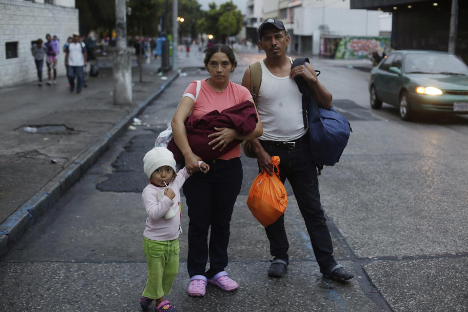 In this Oct. 18, 2018 photo, Honduran migrant Keidy Arreaga holds her 2-month-old baby and the hand of her 3-year-old daughter Keidy, as her brother Wilver, 32, stands by, as the pose for a portrait before leaving Guatemala City by foot with a caravan of other migrants. Keidy said she found out about the caravan on TV, and decided to join because she believes she is doomed to poverty in Honduras after her children’s father abandoned them. (AP Photo/Moises Castillo)