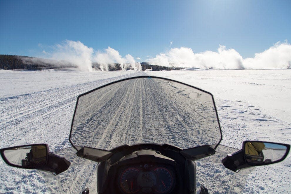 Take in epic snowmobile views of Lower Geyser Basin in Yellowstone National Park