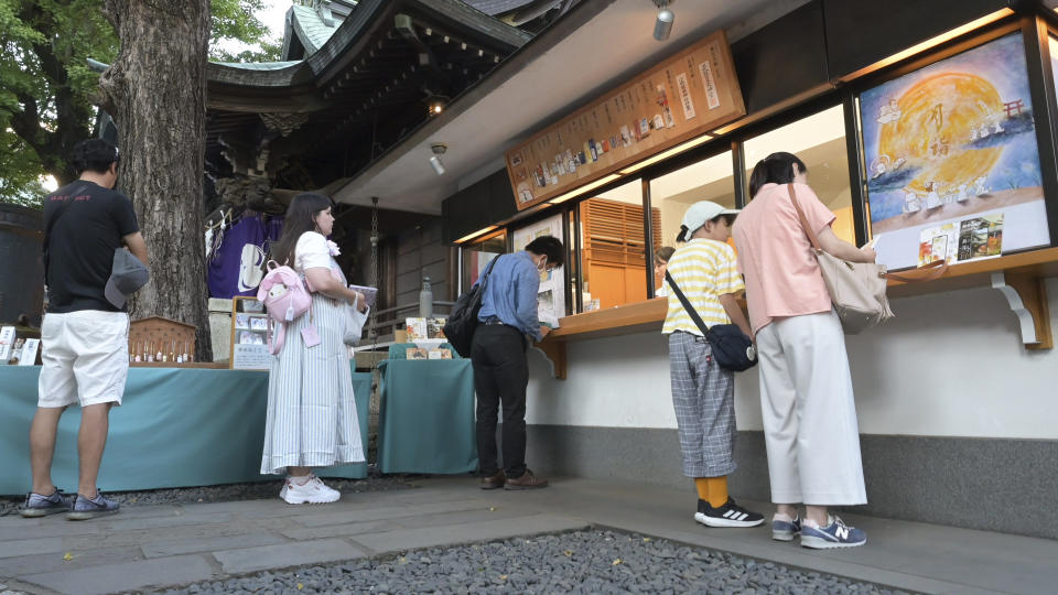 Visitors line up outside a shrine’s office to obtain Goshuin, a seal stamp certifying her visit that comes with elegant calligraphy and the season’s drawings, at Onoterusaki Jinja in Tokyo Sept. 18, 2023. (AP Photo/Ayaka McGill)
